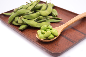 Green soybeans on wooden tray isolated on white background