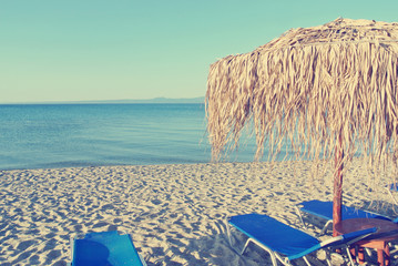 Exotic white sandy beach on a sunny afternoon, with parasols and sun loungers. Filtered image in faded, washed out, retro, Instagram style; nostalgic concept of summer holidays. - 113208099