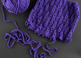 A piece of purple knitting, against a dark background 