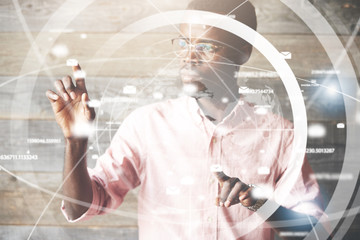 Visual effects. Future technology touch screen interface. High technology concept. Serious African American office worker using futuristic digital device, pointing on sensor screen. Selective focus
