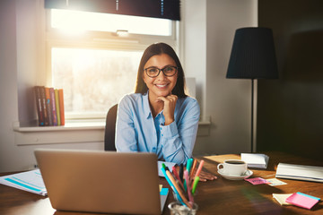 Female entrepreneur sitting at desk - Powered by Adobe