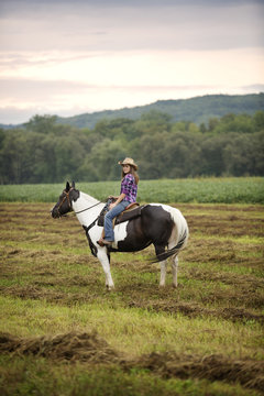 Side view of cowgirl sitting on horse