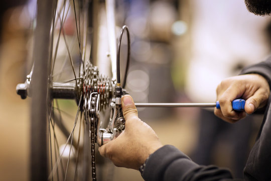 Cropped image of man repairing bicycle in workshop