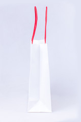 elegant white paper shopping bag with red handle
