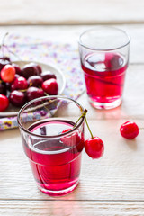 Cherry lemonade on white wooden background.