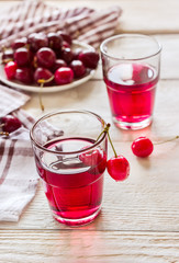 Cherry lemonade on white wooden background.