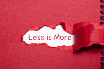 The word less is more appearing behind torn paper. - 113212851