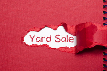 The word yard sale appearing behind torn paper.