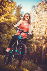 Fototapeta na wymiar woman cyclist rides in the forest on a mountain bike.