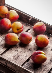 Peaches group in old rustic wooden box white background