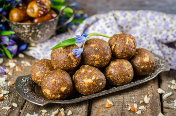 homemade candies with dates and walnuts on vintage try and wooden background. East sweets for ramadan. Selective focus