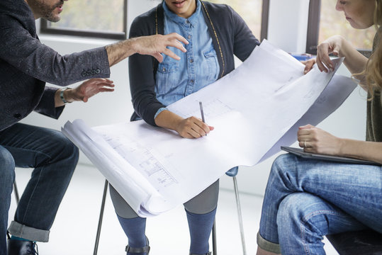 People talking in office, holding plan