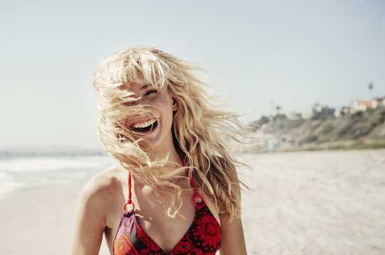 Smiling blond young woman enjoying beach