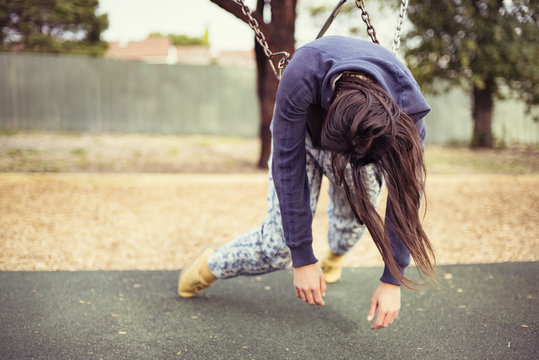 Young woman hanging on swing