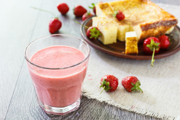 Glass of strawberry smoothie and cheesecake.