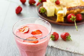 Glass of strawberry smoothie and cheesecake.