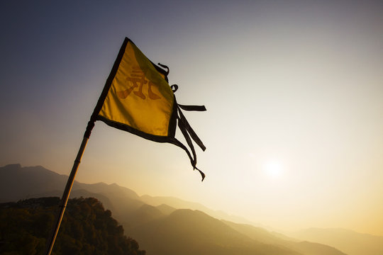 Flag fluttering against sky during sunset