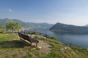 Leere Sitzbank auf einem Aussichtspunkt vor dem Panorama des Iseo-See und der Monte Isola,Lombardei,Italien