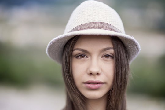 Portrait of young female wearing hat blurred background