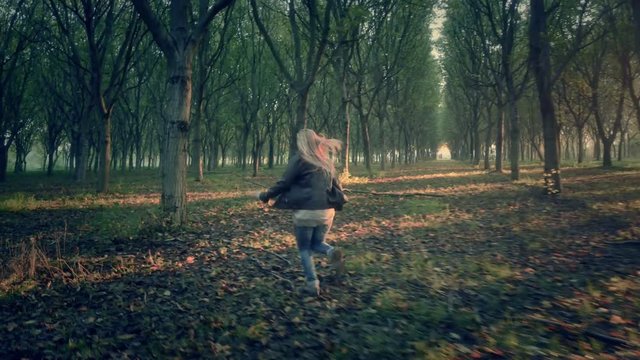 scared afraid female woman runs away escape from murderer chasing her through a dark  forest full of trees looking for help horror scene