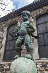 Statue of a boy holding two fishes near Aachen Cathedral