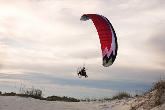 Man paragliding over beach