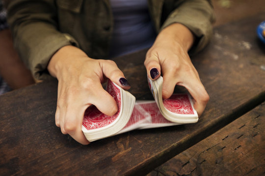 Cropped image of woman shuffling playing card