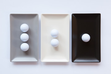Different ceramic dishes with golf balls