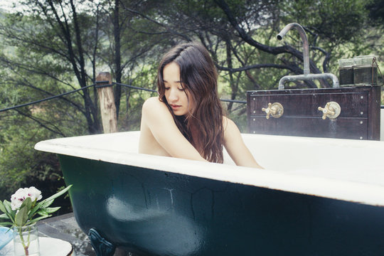 Young beautiful woman relaxing in bathtub