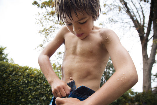 Boy zipping his jeans outdoors
