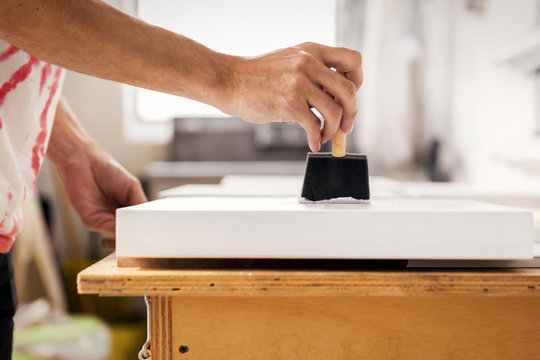 Cropped image of worker painting frames