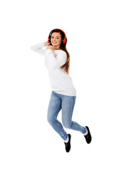 Beautiful young woman jumping and listen music