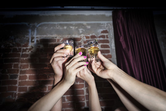 Group of friends toasting with shots of drink