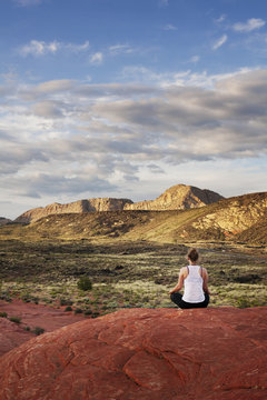 Woman meditating on valley rock,