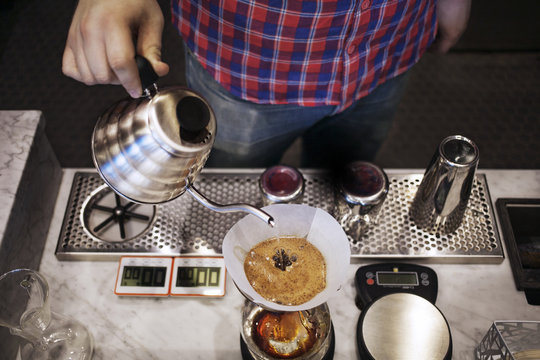 Mid section of barista making coffee