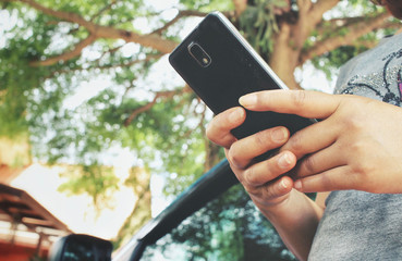 Woman using smart phone with car