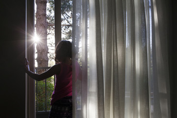 Girl standing by window