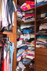 wardrobe with hanged and folded clothes closeup