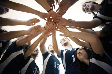 Directly below view of teenage girls stacking hands