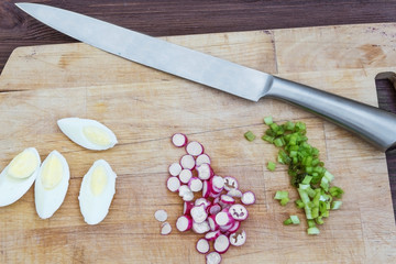 boiled eggs radish and green onion on a wooden board