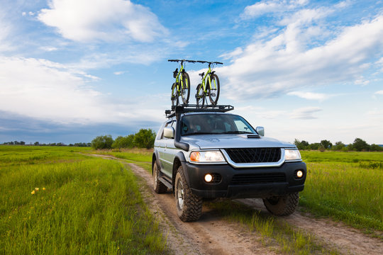 Fototapeta 4x4 SUV with two bicycles on roof rack