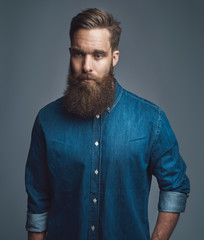 Obraz premium Bearded man in blue denim with serious expression