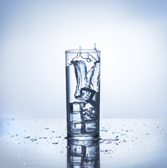 Ice cube makes splash into glass of water