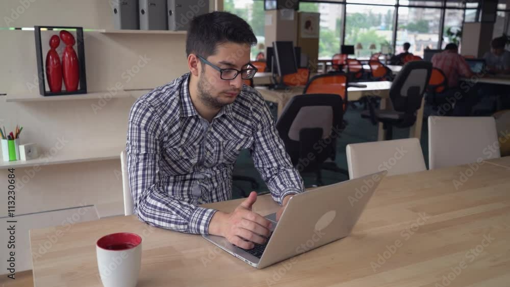 Poster concentrated man at the working place using computer and search information. mixed race male wearing
