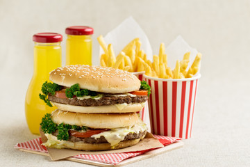 Burger with beef, tomato and herbs. Fries and juice.