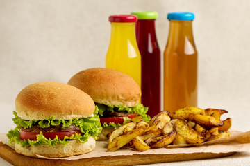 Burger with beef, tomato and herbs. Fries and juice.