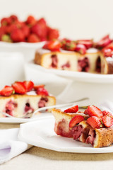 Homemade strawberry cake on a white cake stand.
