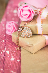 Gift box decor. Wrapped in parchment paper, delicate fresh pink flowers with golden heart