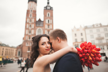 Elegant beautiful wedding couple walking on the main square in Krakow