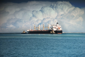 Tugboats push big ship to sea